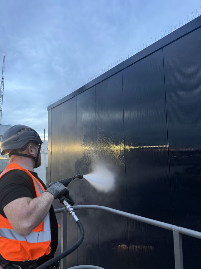 Operative in hi-vis pressure washing dark cladding panels